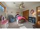 Charming bedroom with a ceiling fan, a rocking chair, and playful decor at 6637 Berry Bush Ln, Evergreen, CO 80439