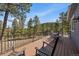 An outdoor deck featuring wooded views and a seating area at 6637 Berry Bush Ln, Evergreen, CO 80439