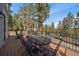 The spacious deck featuring a wrought iron table and chairs offering stunning outdoor views at 6637 Berry Bush Ln, Evergreen, CO 80439