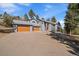 Stunning two-story home with a three-car garage and beautiful landscaping at 6637 Berry Bush Ln, Evergreen, CO 80439