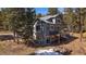 A two-story exterior of the home featuring a porch and yard with snow at 6637 Berry Bush Ln, Evergreen, CO 80439