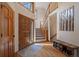 Bright foyer with hardwood floors, wood stairs, and a decorative door leading to the main living area at 6637 Berry Bush Ln, Evergreen, CO 80439