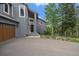 Inviting front entrance with wood door, an American flag, and an attached three-car garage at 6637 Berry Bush Ln, Evergreen, CO 80439