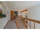 Upstairs hallway with carpet, railing and an open doorway leading to a naturally lit room at 6637 Berry Bush Ln, Evergreen, CO 80439