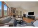 Comfortable living room features a stone fireplace, large windows, and modern decor at 6637 Berry Bush Ln, Evergreen, CO 80439