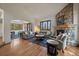 Open concept living area featuring a stone fireplace and hardwood floors perfect for entertaining at 6637 Berry Bush Ln, Evergreen, CO 80439
