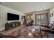 Spacious living room with a view of nature, featuring a leather sectional sofa and exercise equipment at 6637 Berry Bush Ln, Evergreen, CO 80439