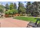 Lush backyard featuring a green lawn, a stone patio, and a wooden fence for added privacy at 20886 Parliament Pl, Parker, CO 80138