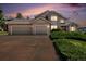 Exterior shot of home at dusk highlighting garage and landscaping at 20886 Parliament Pl, Parker, CO 80138