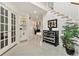 Bright foyer with tile flooring, glass paneled doors, staircase, and decorative cabinet at 20886 Parliament Pl, Parker, CO 80138