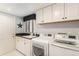 Functional laundry room with washer, dryer, sink, cabinets, and exterior door at 20886 Parliament Pl, Parker, CO 80138