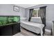 Small bedroom includes a large window that provides natural light, light-colored flooring, and an aquarium at 1102 Conifer Ct, Highlands Ranch, CO 80126