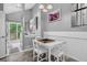 Cozy dining area with white table and chairs next to a light and bright kitchen at 1102 Conifer Ct, Highlands Ranch, CO 80126