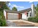 Charming home featuring a two-car garage, red brick, concrete driveway, an American flag, and mature landscaping at 1102 Conifer Ct, Highlands Ranch, CO 80126