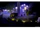 A well-lit home exterior showcasing a landscaped yard at night, highlighting curb appeal with garden bed lighting at 1102 Conifer Ct, Highlands Ranch, CO 80126