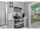Modern kitchen featuring stainless steel appliances and gray cabinetry with backyard access at 1102 Conifer Ct, Highlands Ranch, CO 80126