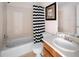 Clean bathroom with a single sink vanity, patterned shower curtain, and tiled shower at 9150 Gale Blvd # 1, Thornton, CO 80260