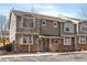 Inviting townhome exterior with stone accents, well-kept landscaping, and dedicated visitor parking spaces at 9150 Gale Blvd # 1, Thornton, CO 80260