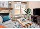 Inviting living room featuring a cozy stone fireplace, plush seating, and natural light from a large window at 9150 Gale Blvd # 1, Thornton, CO 80260