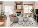 Bright living room with a stone fireplace, sliding glass doors, and hardwood floors with large patterned rug at 9150 Gale Blvd # 1, Thornton, CO 80260