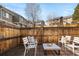 Cozy patio with a wood fence, string lights, seating, and houses in the background at 9150 Gale Blvd # 1, Thornton, CO 80260