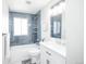 This bathroom features blue subway tile in the shower, white cabinets, and neutral wall paint at 5539 Atchison St, Denver, CO 80239