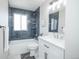 This bathroom features blue subway tile in the shower, white cabinets, and neutral wall paint at 5539 Atchison St, Denver, CO 80239