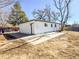 Exterior view of the home with large concrete pad and white siding at 5539 Atchison St, Denver, CO 80239