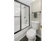 Close up of a toilet next to a bathtub and shower with black trim at 2 Adams Street # 108, Denver, CO 80206