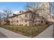 Apartment building exterior featuring brick, fence and landscaping at 2101 S Josephine St # 202, Denver, CO 80210