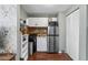Functional kitchenette with appliances, shelving, tiled backsplash, and adjacent storage closet at 2101 S Josephine St # 202, Denver, CO 80210
