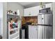 Efficient kitchenette with stainless steel refrigerator, appliances, shelving, and tiled backsplash at 2101 S Josephine St # 202, Denver, CO 80210