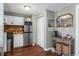 Compact kitchenette with wood floors, appliances, storage shelves, and a decorative mirror at 2101 S Josephine St # 202, Denver, CO 80210