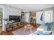 Open living area with gray sofa, wood floors, adjacent storage, TV stand and floral-themed wall at 2101 S Josephine St # 202, Denver, CO 80210