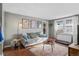 Cozy living room with gray sofa, wood floors, and a round coffee table, filled with natural light at 2101 S Josephine St # 202, Denver, CO 80210