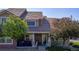 Charming townhome featuring a covered front porch, well-maintained landscaping, and a welcoming entrance at 10449 Paris St # 207, Commerce City, CO 80640