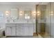 Bright bathroom featuring a double vanity with elegant lighting and a glass-enclosed shower with stylish tile work at 629 Jackson St, Lafayette, CO 80026