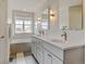 Bright bathroom featuring a double vanity with elegant lighting, and a soaking tub under a window with neighborhood views at 629 Jackson St, Lafayette, CO 80026