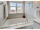 Bright bathtub under a large window with neighborhood views at 629 Jackson St, Lafayette, CO 80026