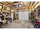 Spacious garage with wooden support beams, storage shelving, and a large roll-up door at 130 N 8Th Ave, Brighton, CO 80601