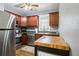 Compact kitchen with stainless steel appliances, wooden cabinets, and a butcher block island, blending style and functionality at 130 N 8Th Ave, Brighton, CO 80601