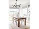 Elegant dining room with modern chandelier, wood table, and large windows overlooking the backyard at 2685 S Acoma St, Denver, CO 80223