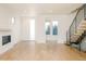 Sunlit living room featuring hardwood floors, fireplace, and modern floating staircase at 2685 S Acoma St, Denver, CO 80223