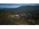 Luxury mountain home with pool, tennis court, and lush landscaping surrounded by forest at 34650 Sleeping Fox Trl, Evergreen, CO 80439