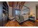 Beautiful bedroom features a four poster bed, vaulted wood ceiling, hardwood floors and built in shelves at 34650 Sleeping Fox Trl, Evergreen, CO 80439