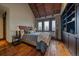 Comfortable bedroom boasts hardwood floors, vaulted wood ceilings, and natural light at 34650 Sleeping Fox Trl, Evergreen, CO 80439