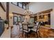 Elegant dining room with a round table, high ceilings, wood beams, and access to the kitchen at 34650 Sleeping Fox Trl, Evergreen, CO 80439