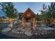 Elegant home entrance with custom stonework, water feature, and professional landscaping at 34650 Sleeping Fox Trl, Evergreen, CO 80439