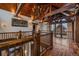 Hallway with wood floors, wood beams, iron railings, and an eagle sculpture on the wall at 34650 Sleeping Fox Trl, Evergreen, CO 80439
