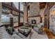 Stunning living room with stone fireplace, floor-to-ceiling windows, and mountain views at 34650 Sleeping Fox Trl, Evergreen, CO 80439